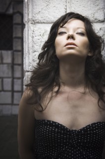 Italian woman leaning against wall with eyes closed