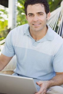 Mixed race man in hammock using laptop