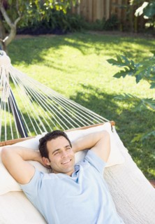 Mixed race man relaxing in hammock