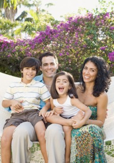 Smiling family sitting in garden