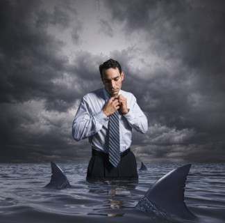 Latin businessman standing in shark infested waters
