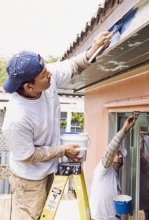 Latin man painting roof eaves