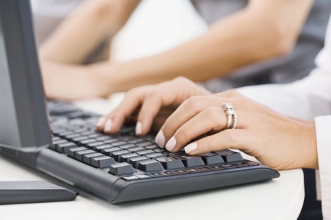 Hispanic woman typing on keyboard