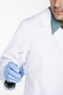 Hispanic scientist holding test tube full of water