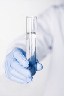 Hispanic scientist holding test tube full of water