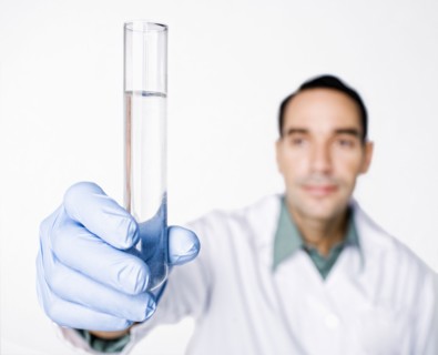 Hispanic scientist holding test tube full of water