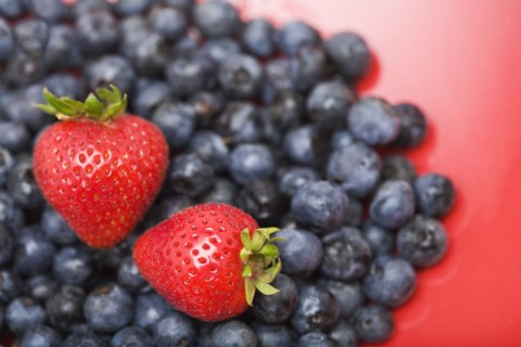 Strawberries on pile of blueberries