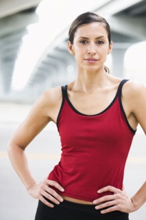 Hispanic woman in sportswear standing in urban area
