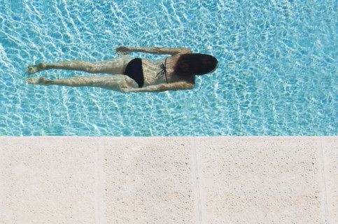 Mixed race woman swimming in pool