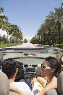 Hispanic couple driving in convertible