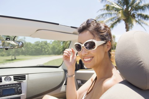 Hispanic woman riding in convertible