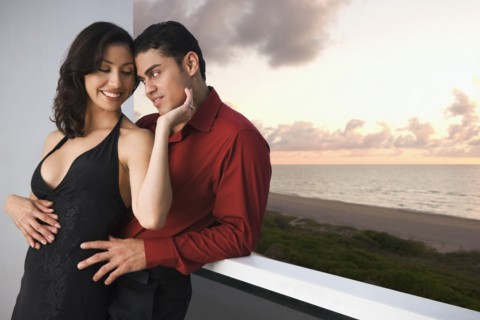 Hispanic couple hugging on balcony