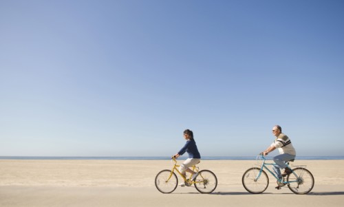 Couple riding bicycles on beach