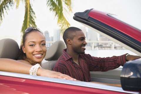 African American couple driving in convertible