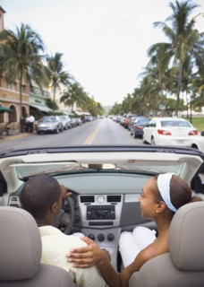 African American couple driving in convertible