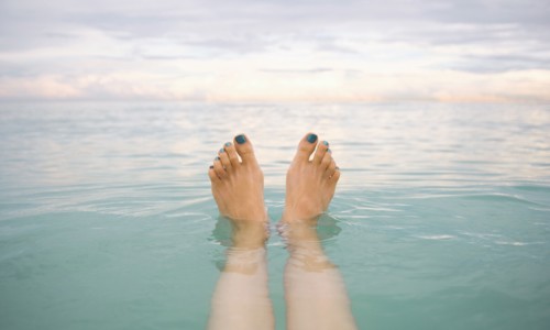 Caucasian woman's feet floating in tropical water
