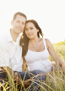 Caucasian couple sitting in tall grass