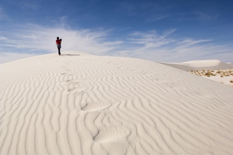 Man climbing sand dune in desert