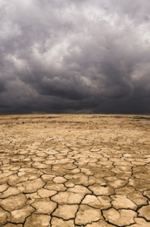 Cracked earth under cloudy sky in desert landscape