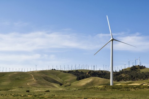 Wind turbines lining hilltop in rolling landscape