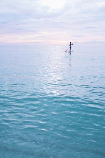 Caucasian man standing on paddleboard in ocean