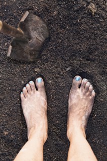 Mixed race woman barefoot in dirt