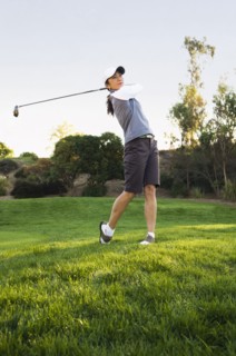 Mixed race woman playing golf on golf course