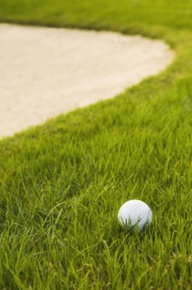 Close up of golf ball near sand trap on golf course