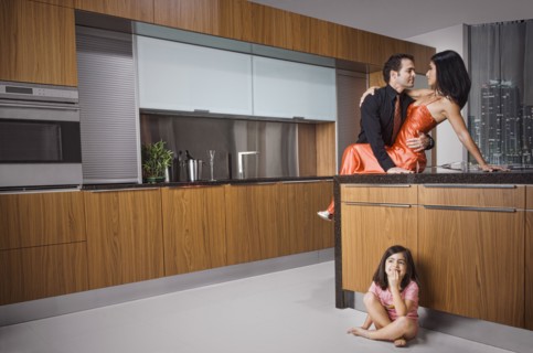 Caucasian girl eavesdropping on parents in kitchen