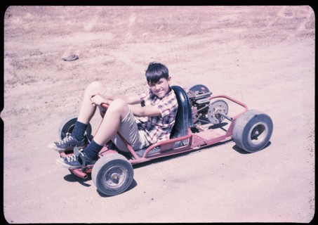 Portrait of Caucasian boy sitting on go-cart
