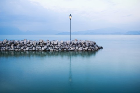 Lamp on stone breakwall in ocean