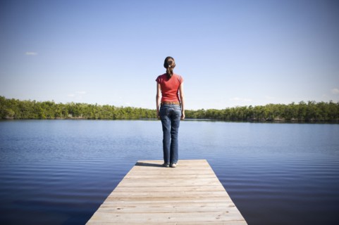 Mixed Race woman at the edge of dock at lake