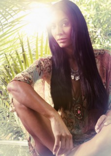 Exotic Hispanic woman sitting near foliage