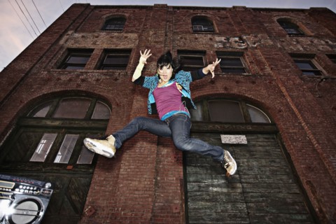 Chinese woman breakdancing in urban area