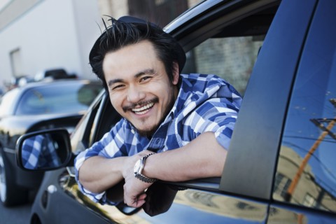 Smiling mixed race man in compact car