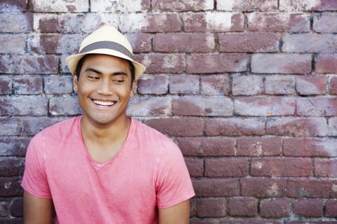 Smiling Asian man near brick wall