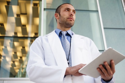 Doctor using digital tablet outdoors