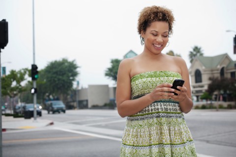 African American woman text messaging on cell phone