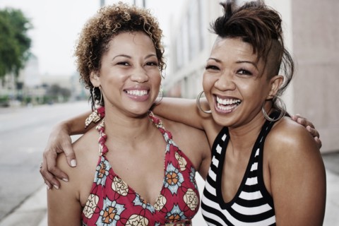 Smiling women hugging on urban street