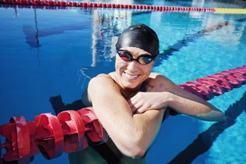 Competitive swimmer leaning on rope in swimming pool