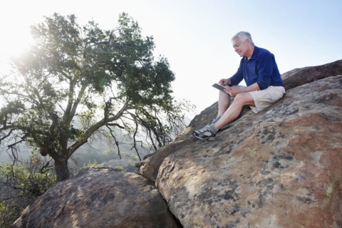 Caucasian man using digital tablet in remote area
