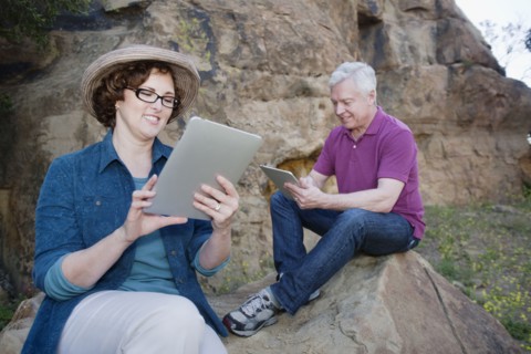 Caucasian couple using digital tablet in remote area
