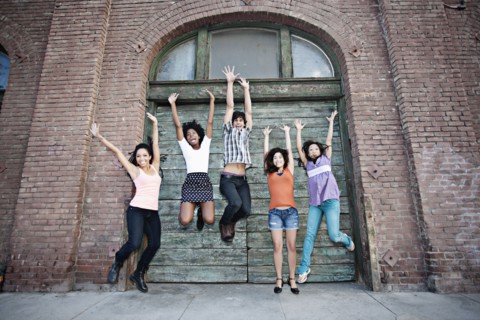 Friends jumping on urban sidewalk