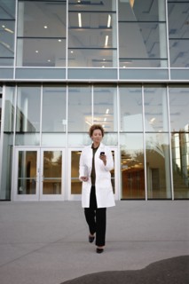 Doctor walking and text messaging on cell phone