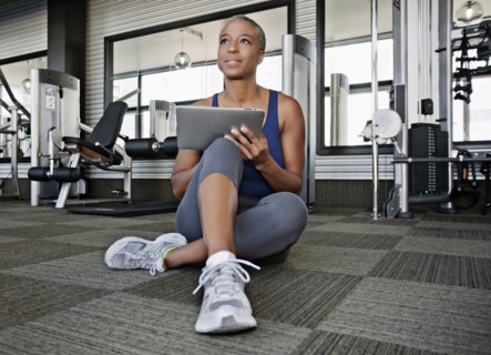 African American woman using digital tablet in health club