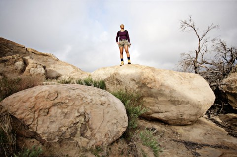 Black woman standing on top of rock
