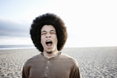 Mixed race man shouting on beach