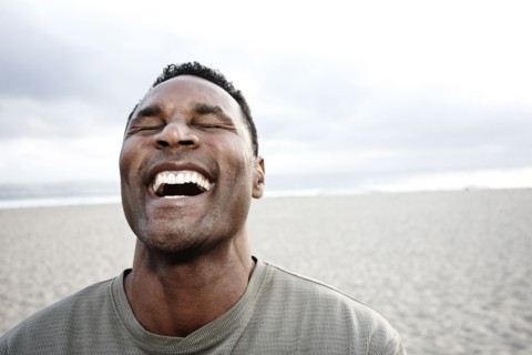 Black man laughing on beach