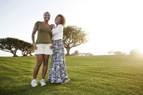 African American mother and daughter standing in park