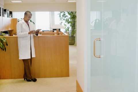 Black doctor using digital tablet